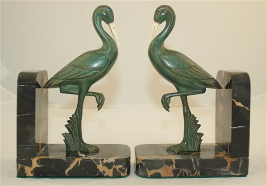 A pair of French Art Deco bronze and ivory stork bookends, 7.5in.